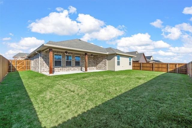 back of house featuring a lawn and a patio area