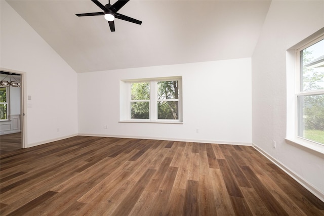 unfurnished room featuring dark hardwood / wood-style flooring, ceiling fan with notable chandelier, and vaulted ceiling