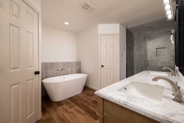 bathroom with independent shower and bath, vanity, and hardwood / wood-style floors