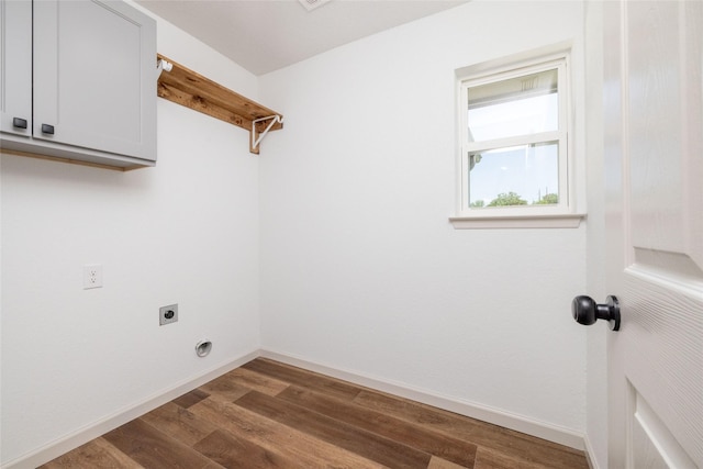 laundry room with cabinets, electric dryer hookup, and dark wood-type flooring