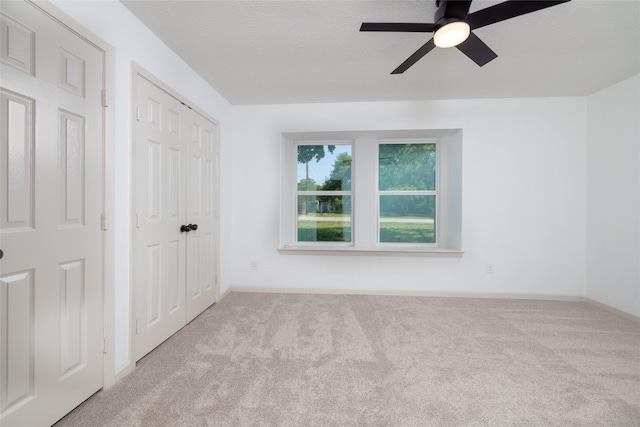 carpeted empty room featuring ceiling fan and a textured ceiling