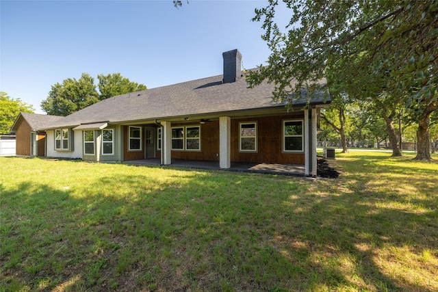 rear view of house featuring a yard, central AC unit, and a patio