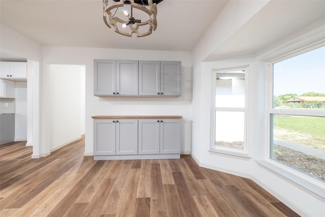 unfurnished dining area with hardwood / wood-style floors and a chandelier