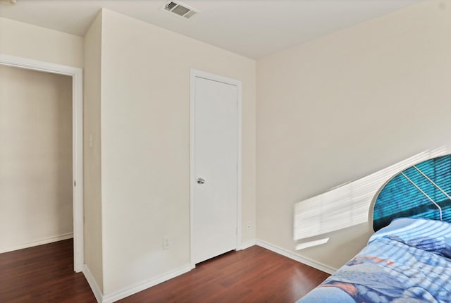 bedroom with dark hardwood / wood-style floors