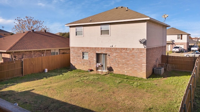 rear view of house with a lawn and central AC unit