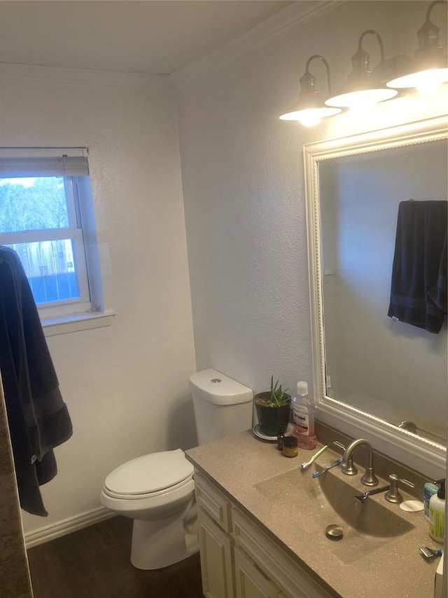 bathroom featuring hardwood / wood-style floors, vanity, toilet, and crown molding