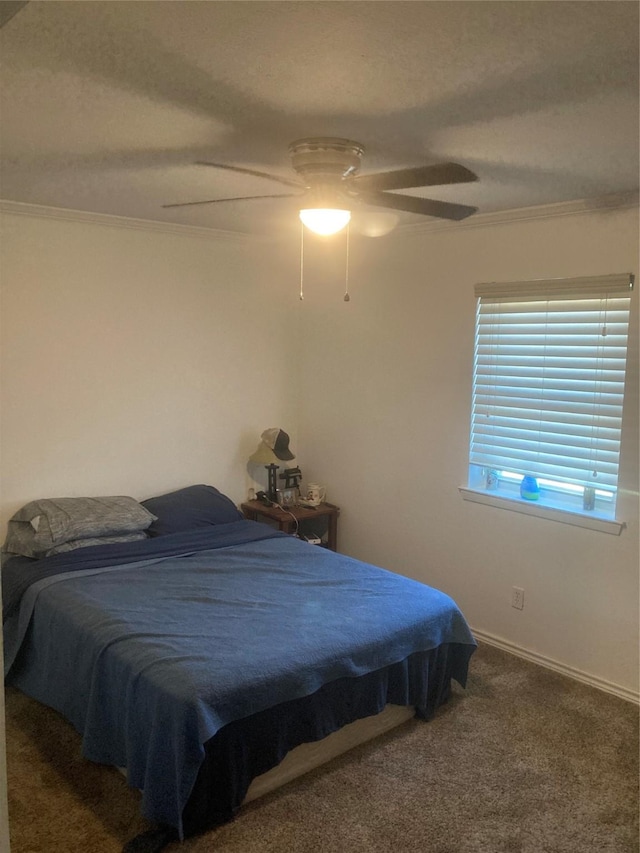 bedroom with dark colored carpet, ceiling fan, and crown molding