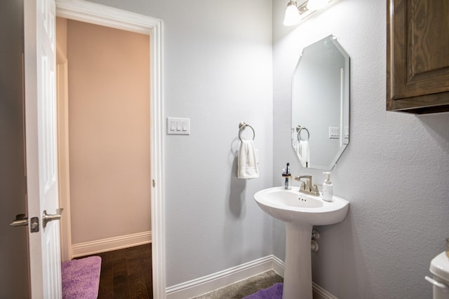 bathroom featuring hardwood / wood-style floors, toilet, and sink