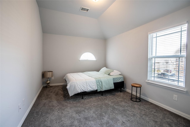 bedroom with dark carpet and vaulted ceiling