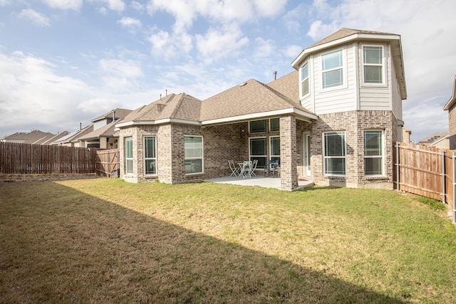 back of house featuring a lawn and a patio area