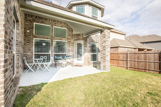 back of property with a patio area and a lawn