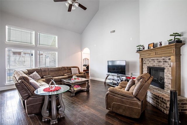 living room with dark hardwood / wood-style floors, a healthy amount of sunlight, a fireplace, and high vaulted ceiling