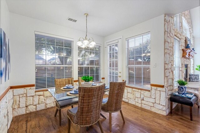 dining area with hardwood / wood-style flooring and an inviting chandelier