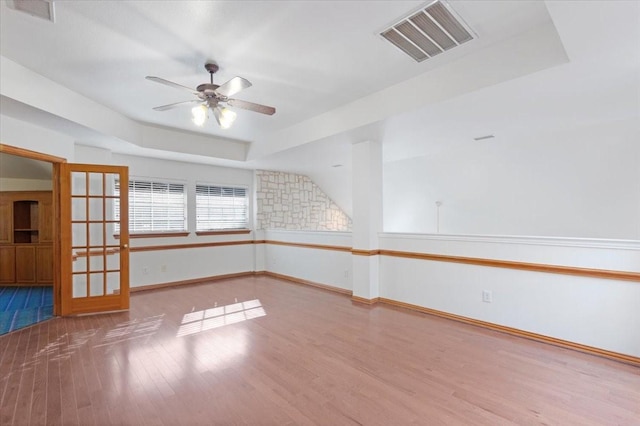 unfurnished room featuring hardwood / wood-style flooring, ceiling fan, and a tray ceiling