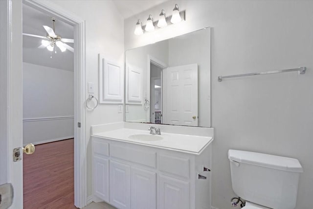 bathroom featuring wood-type flooring, vanity, toilet, and ceiling fan