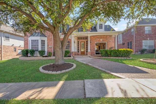 view of front of house featuring a front yard and brick siding