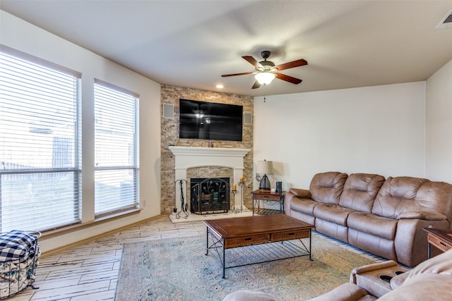 living room with ceiling fan, a fireplace, and light hardwood / wood-style floors