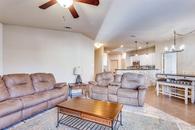 living room with ceiling fan with notable chandelier and light tile patterned flooring