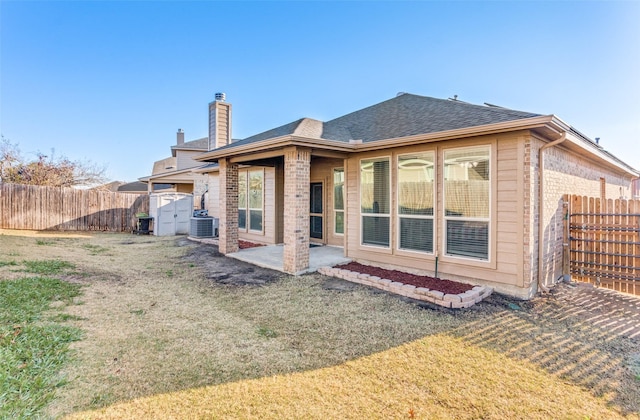 back of property featuring a lawn, a patio, central air condition unit, and a storage unit