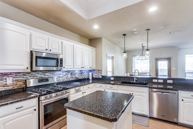 kitchen featuring appliances with stainless steel finishes, sink, decorative backsplash, and white cabinets