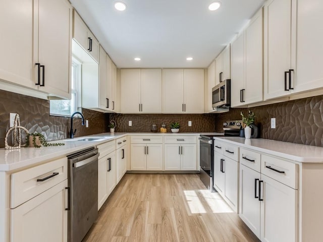 kitchen with white cabinets, appliances with stainless steel finishes, and backsplash