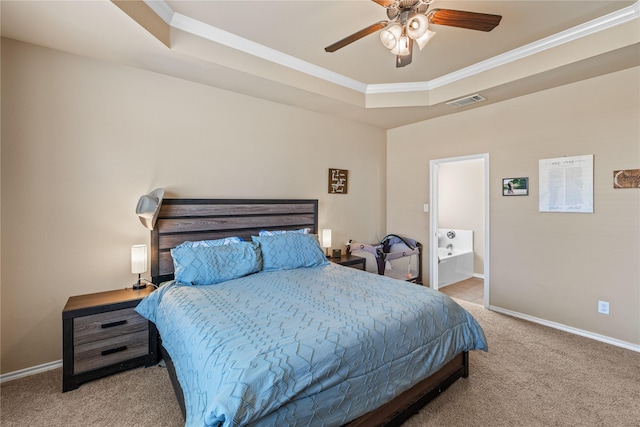 carpeted bedroom featuring connected bathroom, a tray ceiling, ceiling fan, and ornamental molding