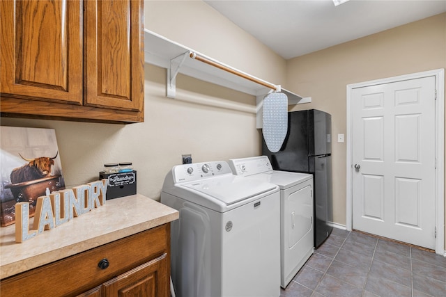 washroom with washer and dryer, light tile patterned flooring, and cabinets