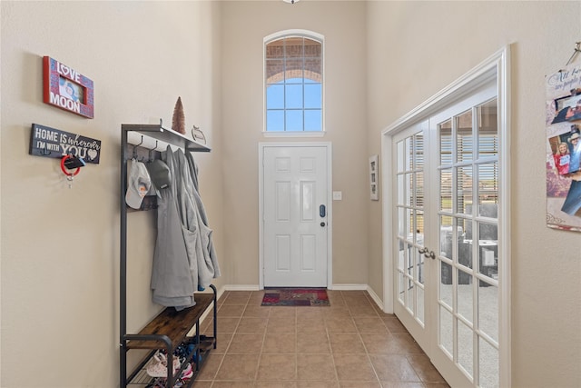 tiled entrance foyer featuring a wealth of natural light, french doors, and a high ceiling