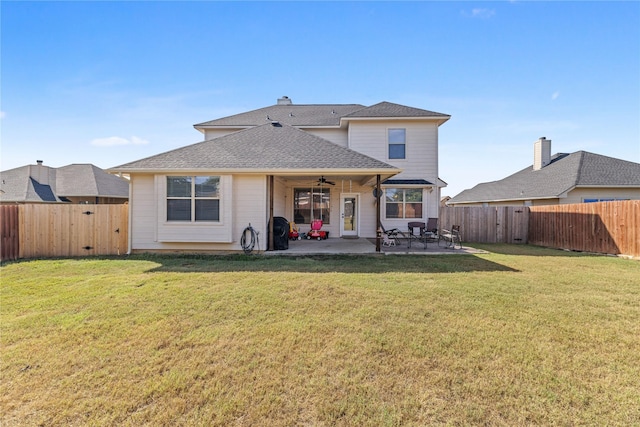 back of property with a lawn, a patio area, and ceiling fan