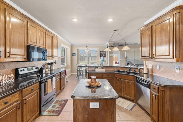 kitchen with appliances with stainless steel finishes, crown molding, sink, pendant lighting, and a kitchen island