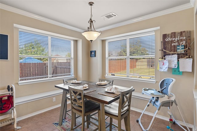 dining room with a healthy amount of sunlight, light tile patterned floors, and crown molding