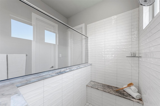 bathroom featuring a healthy amount of sunlight and tiled shower