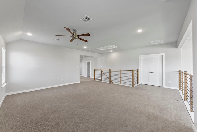 empty room featuring carpet floors, vaulted ceiling, and ceiling fan