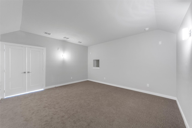 carpeted empty room featuring lofted ceiling