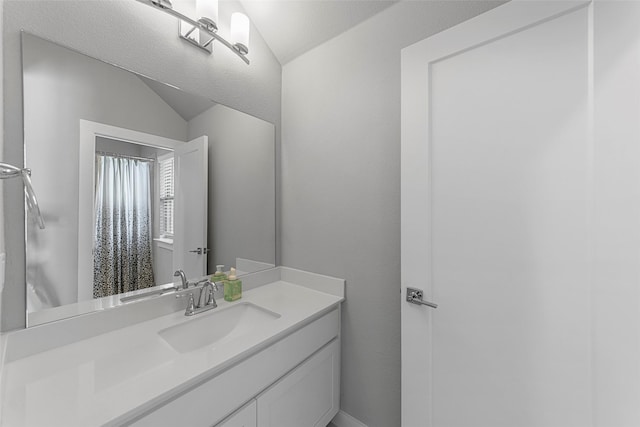 bathroom featuring vanity and vaulted ceiling