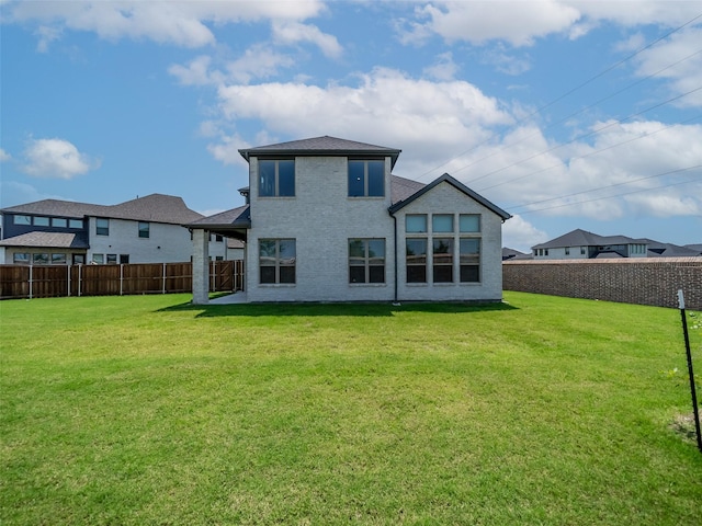 rear view of house featuring a yard