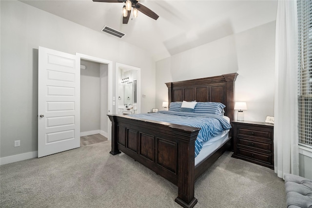 bedroom featuring ensuite bath, ceiling fan, light carpet, and lofted ceiling