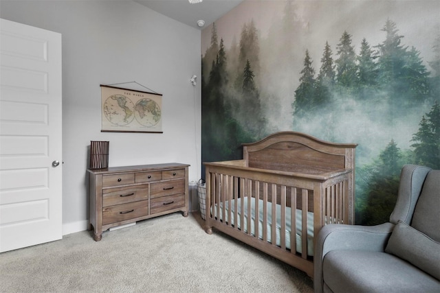 bedroom with light carpet and a nursery area