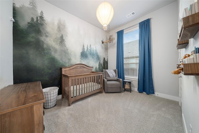 bedroom with light carpet and a nursery area