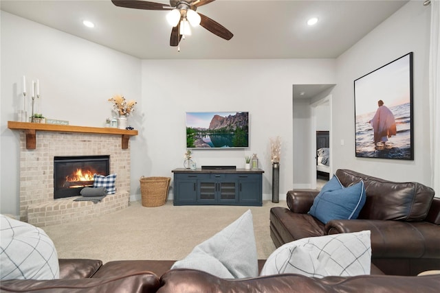 living room featuring ceiling fan, a fireplace, and carpet