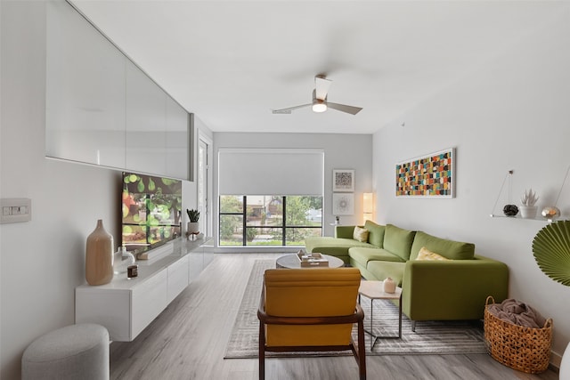 living room featuring ceiling fan and light hardwood / wood-style flooring