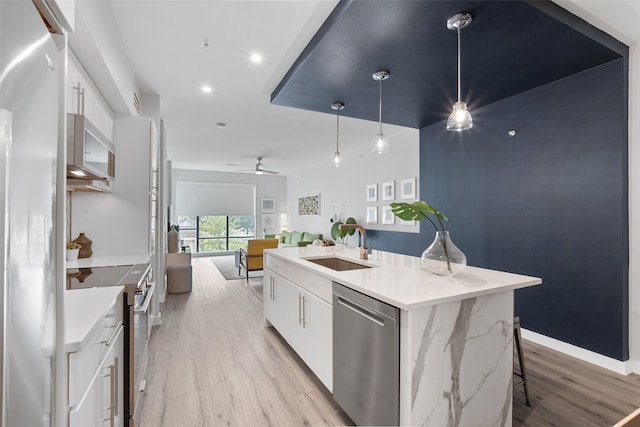 kitchen featuring a kitchen island with sink, white cabinets, and stainless steel appliances