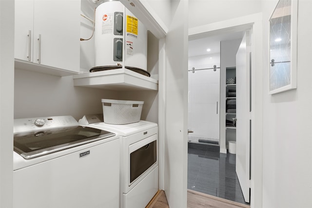 washroom with washer and dryer and water heater