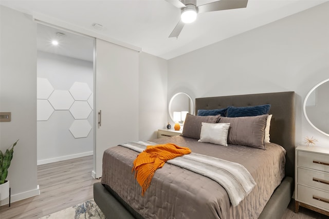 bedroom with light hardwood / wood-style floors and ceiling fan