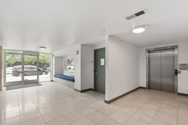 interior space featuring light tile patterned floors and elevator