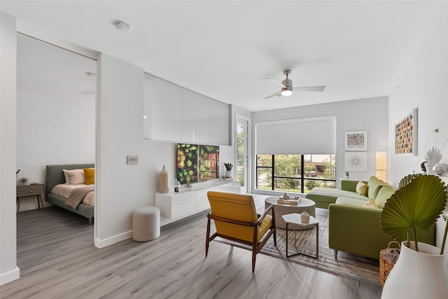 living room with ceiling fan and light hardwood / wood-style flooring