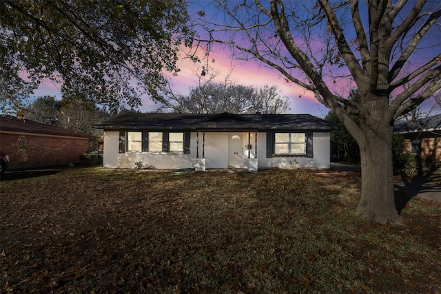 ranch-style home with a yard