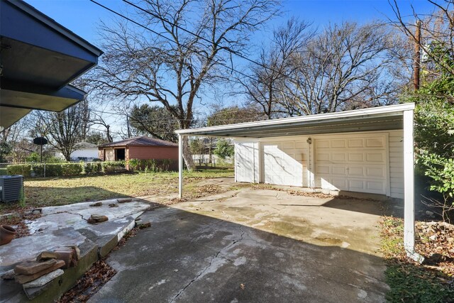 view of patio featuring a garage, an outdoor structure, and central air condition unit