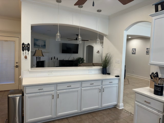 kitchen featuring decorative light fixtures, white cabinetry, and ornamental molding