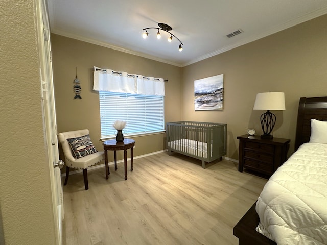 bedroom featuring crown molding and light hardwood / wood-style flooring